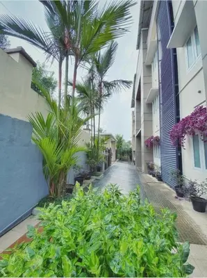 a street with palm trees and plants next to a building at Wayanad Cliff Hotel Apartments in Kalpetta