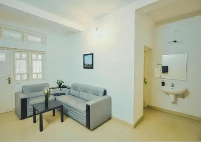 a living room with a couch and a sink at Wayanad Cliff Hotel Apartments in Kalpetta