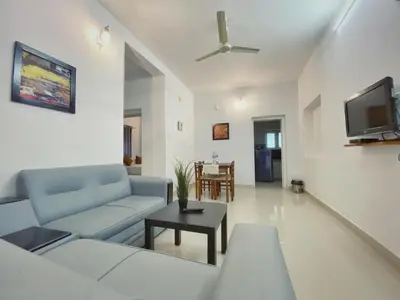 a living room with a blue couch and a table at Wayanad Cliff Hotel Apartments in Kalpetta