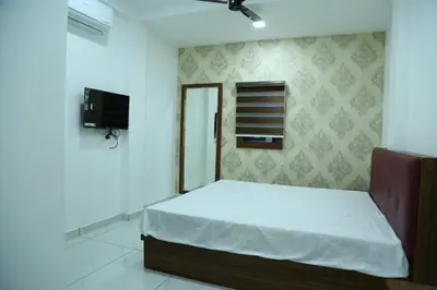 a bedroom with a bed and a tv on the wall at Kurianplackal Residency in Alwaye