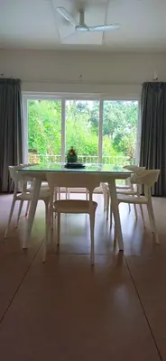 a table in a room with a large window at Wayanad Empire Colonial Villa in Kalpetta