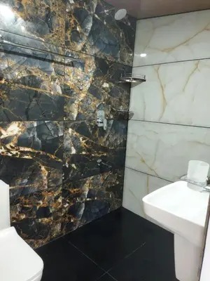 a bathroom with a white sink and a marble wall at Springfield service villa in Mananthavady
