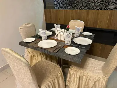 a table with chairs and white plates on it at Ponmari Villa in Ooty