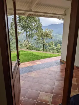 an open door to a porch with a view at Moksha at Infinity Valley in Kotagiri
