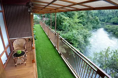 a balcony of a house with a view of a river at Mazhavilkadu ForestResort & Restaurant in Kozhikode