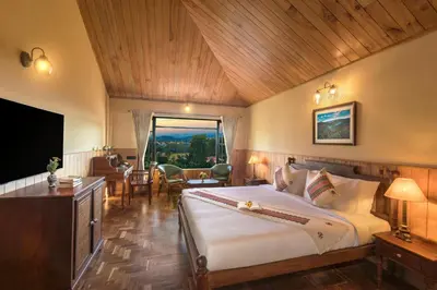 a bedroom with a large bed and a large window at Willow Hill by Nature Resorts and Stays in Ooty