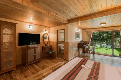 a living room with wood paneling and a flat screen tv at Willow Hill by Nature Resorts and Stays in Ooty