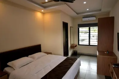 a bedroom with a large bed and a window at ARAKKAL GUESTHOUSE in Kalpetta
