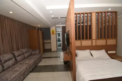 a living room with a couch and a bed at ARAKKAL GUESTHOUSE in Kalpetta