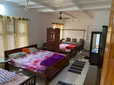 a group of four beds in a room at Shilpa Vikas Homestay in Madikeri