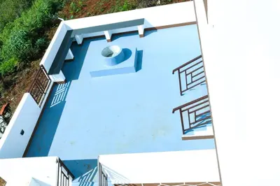 an overhead view of a blue swimming pool at JDP Villa 2 Bhk House in Ooty