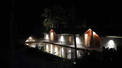 a house at night with its lights on at Maayaa riverside villa by KPM Tripenta in Attappādi
