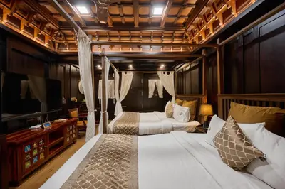 a bedroom with two beds and a flat screen tv at Maliekal Heritance Cherai Beach Cochin in Cherai Beach