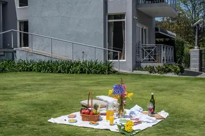 a picnic table with a basket of fruit and a bottle of wine at Kalpavriksha 4BR Luxury Villa - Xplore Indo in Kotagiri