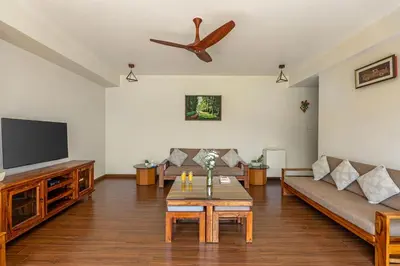 a living room with a couch and a flat screen tv at Kalpavriksha 4BR Luxury Villa - Xplore Indo in Kotagiri