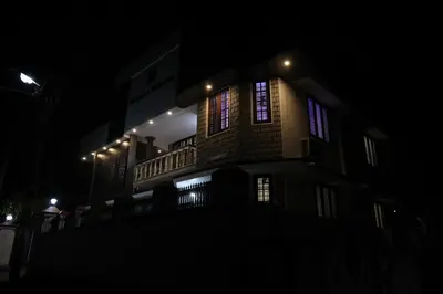 a building with lights on the side of it at night at Malpans Mansion Villa in Nedumbassery