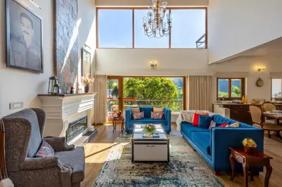 a living room with blue couches and a fireplace at amã Stays & Trails - Werifesteria, Coonoor in Coonoor