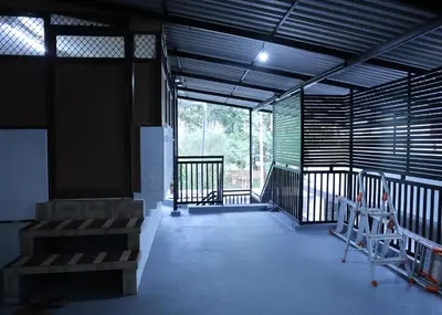 an empty room with a large window and some chairs at Malpans Mansion in Nedumbassery