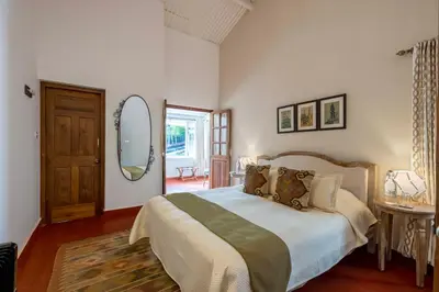 a bedroom with a large bed and a mirror at amã Stays & Trails - Aberdeen, Coonoor in Wellington Town