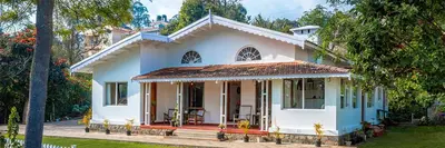 a large white house with a porch at amã Stays & Trails - Aberdeen, Coonoor in Wellington Town