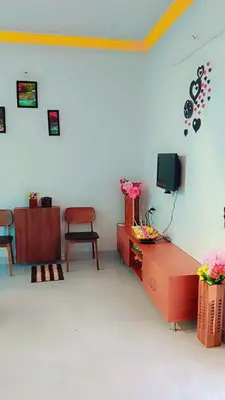 a living room with a tv and a chair at Kailash Guest Home in Mysore