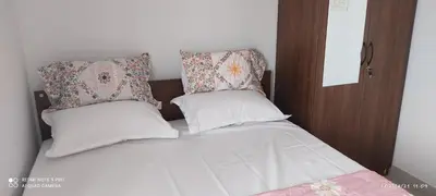 a bed with two pillows on top of it at Kailash Guest Home in Mysore