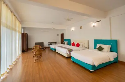 a hotel room with two beds and a table at Misty Heights by The Sanihara in Vayittiri