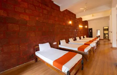 a row of beds lined up against a brick wall at Misty Heights by The Sanihara in Vayittiri