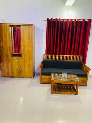 a living room with a couch and a red curtain at Flowers Villa in Ambalavayal