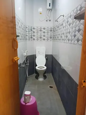 a bathroom with a toilet and a purple stool at KUKAL CASTLE in Tiruppūr