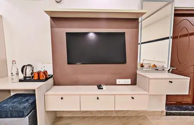 a living room with a tv on a wall at Kaadgal Resort in Kanakapura