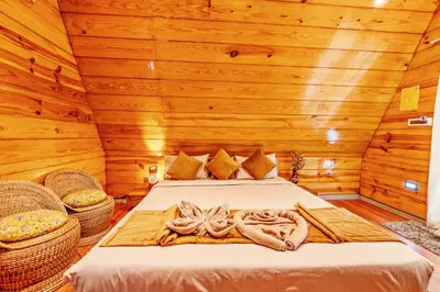 a bedroom with a bed in a wooden cabin at Kaadgal Resort in Kanakapura
