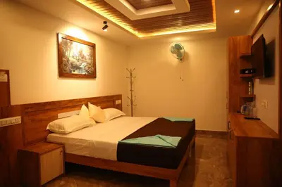 a bedroom with a bed and a television in it at Bhuvanam homestay in Kalpetta