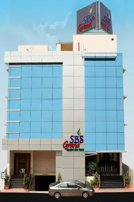 a car parked in front of a building with a sbs car dealership at SBS Grand in Coimbatore