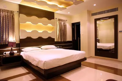 a bedroom with a large bed and a large mirror at SBS Grand in Coimbatore