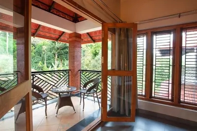 a room with a balcony with a table and chairs at StayVista at Regal Retreat 5BR - Big Villa with Pvt Pool in Wayanad