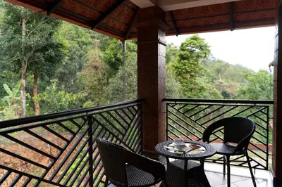 a patio with a table and chairs on a balcony at StayVista at Regal Retreat 5BR - Big Villa with Pvt Pool in Wayanad