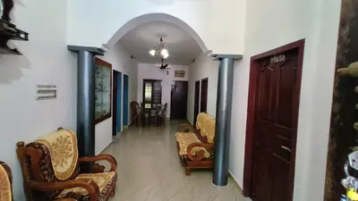 a hallway of a house with chairs and a table at Dragster Homes in Kizhake Chālakudi