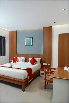 a bedroom with a large bed with red pillows at RITZ AVENUE LUXURY HOTEL in Mahe