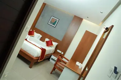 a view of a bedroom with a bed and a chair at RITZ AVENUE LUXURY HOTEL in Mahe