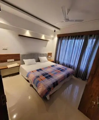a bedroom with a bed and a large window at Spicy Nest Resort in Pinangode
