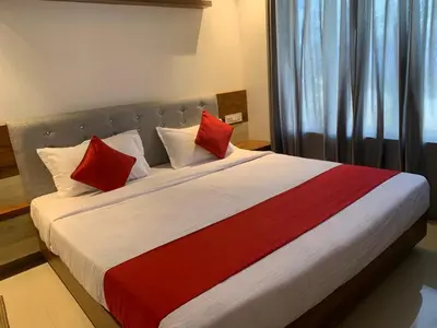 a bedroom with a large bed with red and white pillows at Spicy Nest Resort in Pinangode