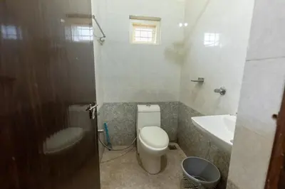 a small bathroom with a toilet and a sink at San Unik Homestay in Nilambūr