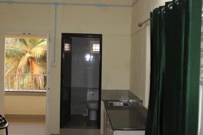 a bathroom with a toilet and a green shower curtain at San Unik Homestay in Nilambūr