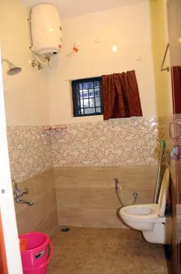 a bathroom with a toilet and a window at Franc Villa - Kothagiri in Kotagiri