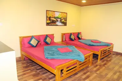 two beds in a room with pink sheets at Franc Villa - Kothagiri in Kotagiri
