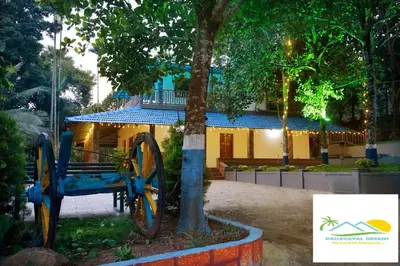a blue cart sitting next to a tree in front of a building at PADAVAYAL GREENS in Attappādi