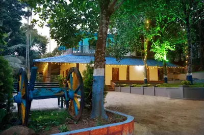 a blue cart next to a tree in front of a building at PADAVAYAL GREENS in Attappādi
