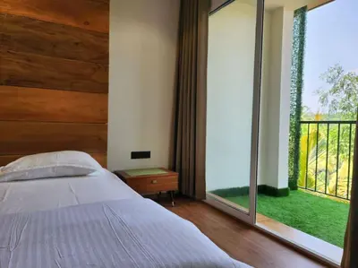a bedroom with a bed and a large window at Gulzar 2BHK Service Apartment, kannur in Kannur