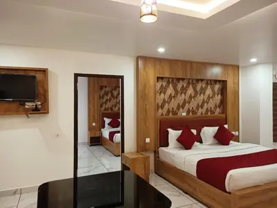 a hotel room with a bed and a tv at Mayo Suites in Palakkad